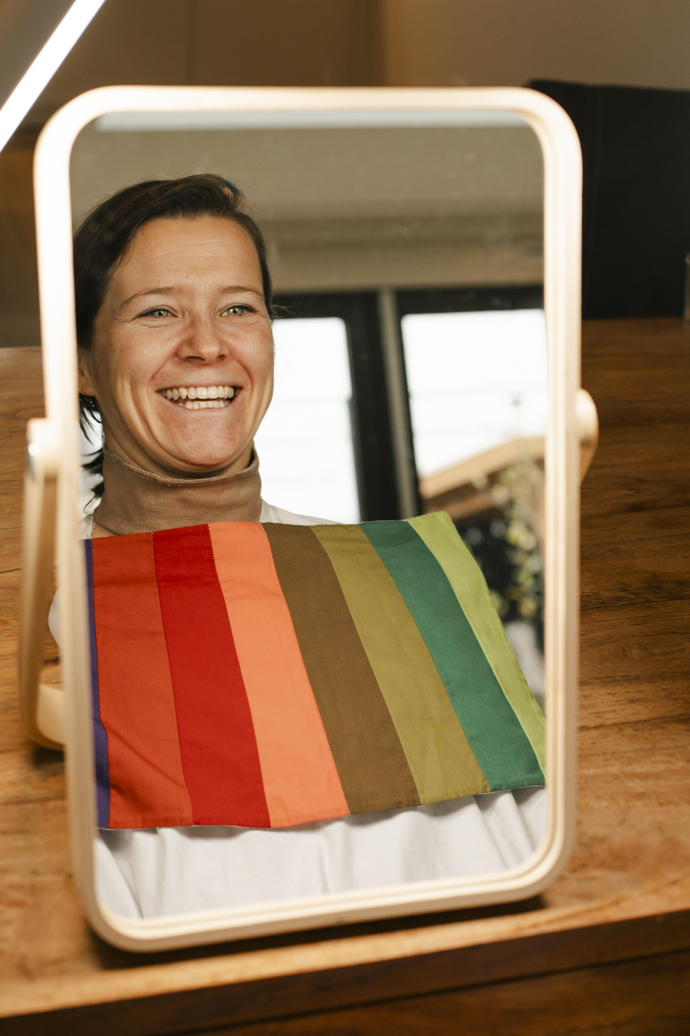 Een dame voor de spiegel tijdens een kleuranalyse door Sandra Kort van Kortom Kleur.