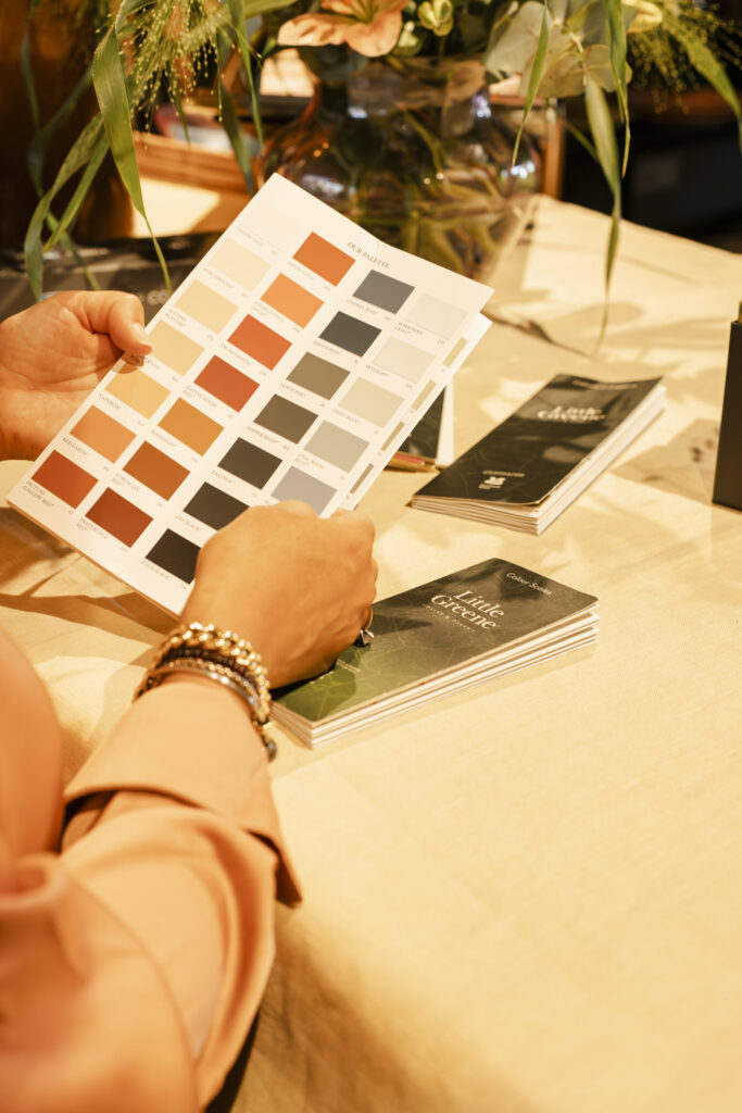 Personal branding shoot van interieurstylist Laura. Ze zit achter haar werkplek en laat kleurstalen zien.